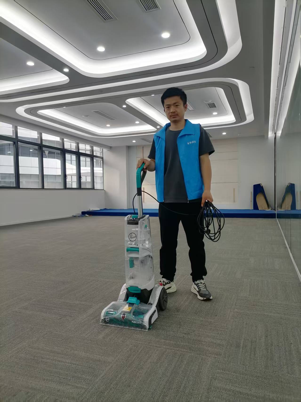 华洁士工程师携带三合一地毯清洗机在办公区地毯现场作业，轻便单人单机即可完成