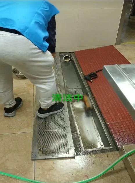 养老机构厨房下水道清洗施工中实拍：作业人员拆卸篦子除油