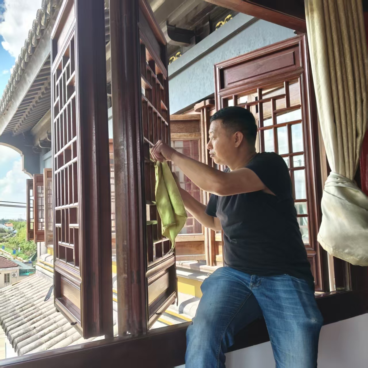 作业人员逐格手工擦拭寺院老式木格扇门窗
