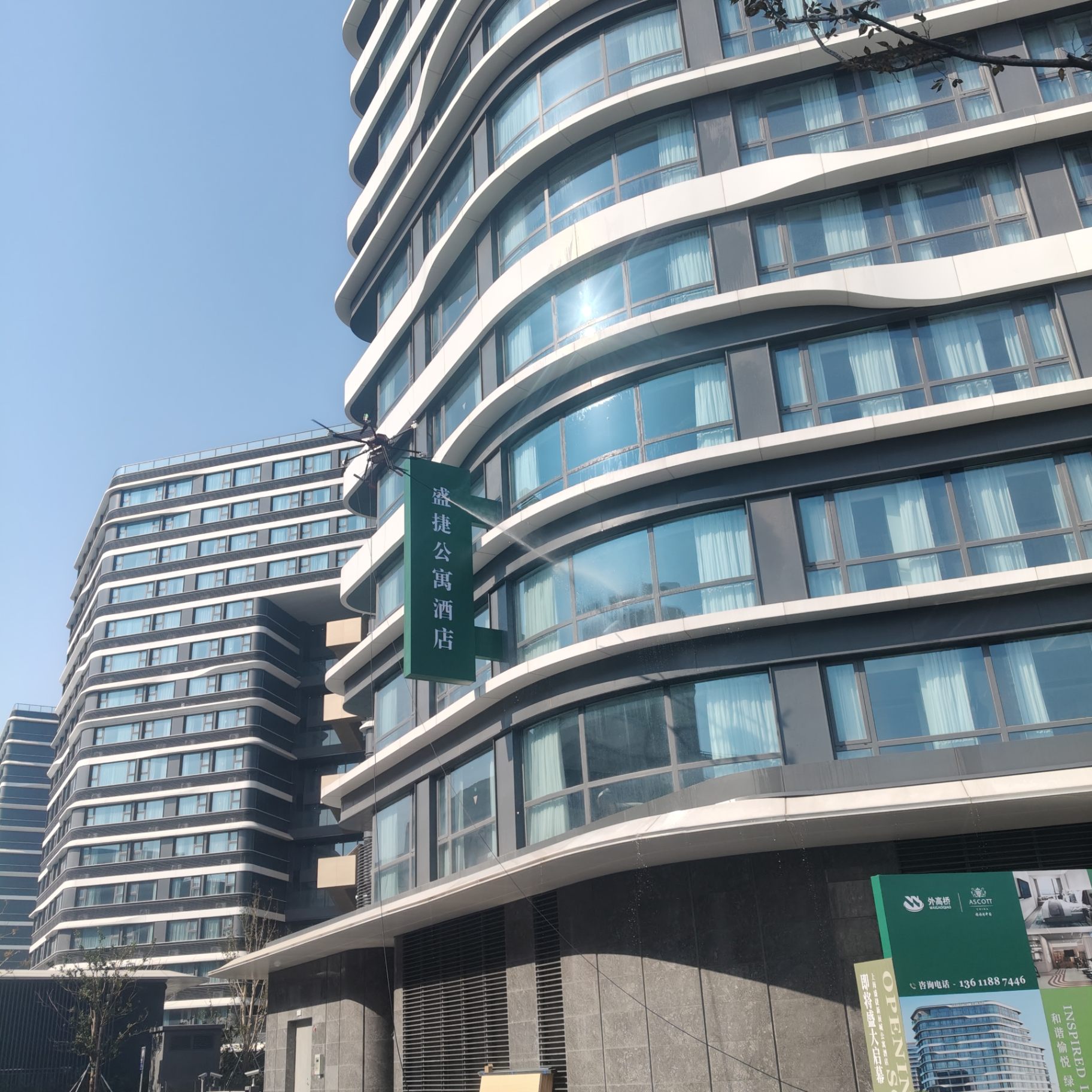 盛捷公寓酒店项目：清洗无人机贴近玻璃幕墙悬停作业，作业高度约 60 米