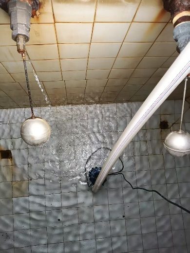 水箱内壁清洗前后效果对比：左侧瓷砖已清洗发白、右侧仍见锈渍污垢，浮球阀与液位管清晰可见