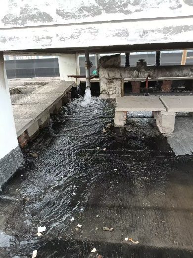 水箱内部旋转喷头高压冲洗作业实拍：软管旋转冲洗头正在冲刷箱底沉积物